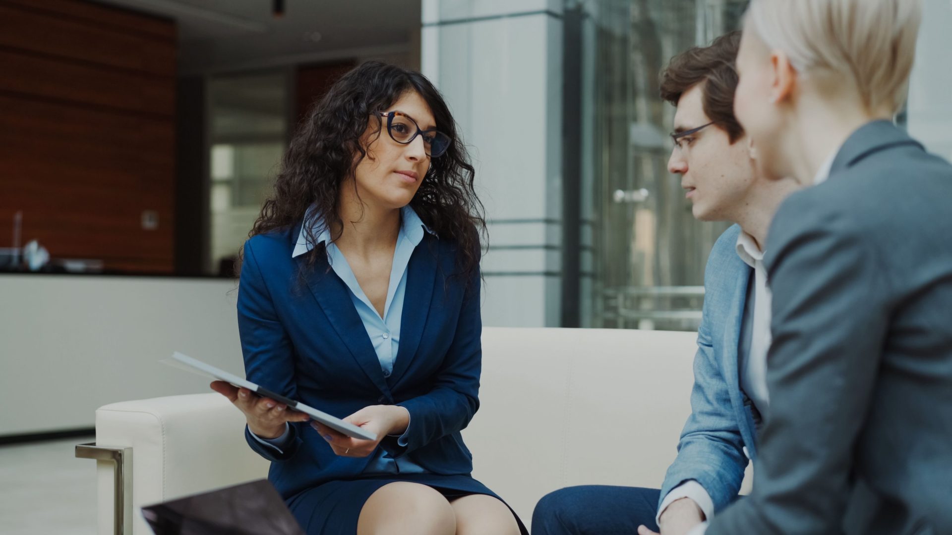 A professional meeting with a team discussing business strategies in a modern office setting.